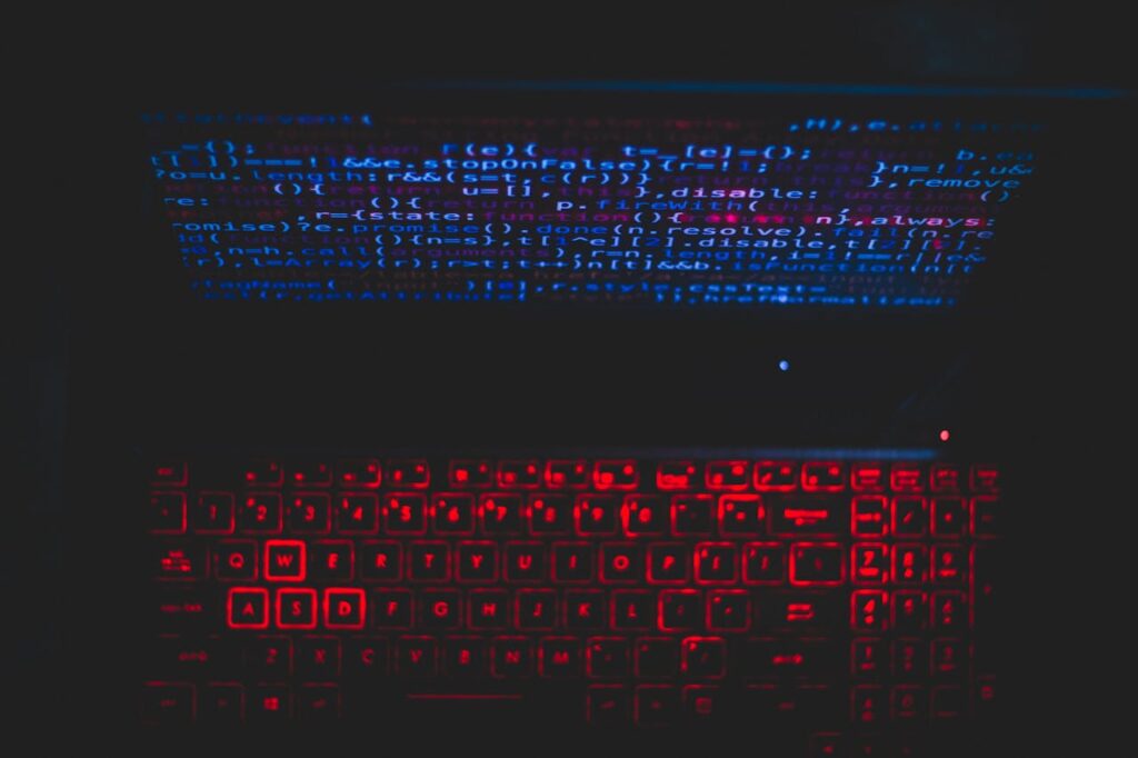 pexels-photo-1933900 Dark-themed laptop setup with a red glowing keyboard and code on screen, ideal for tech enthusiasts.